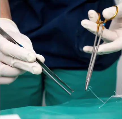 doctor stitching about performing an incision and drainage procedure